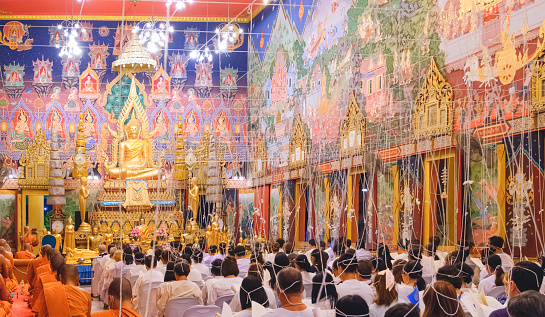 Samutsakhon, Thailand - December31, 2023 : Thai Buddhists and monks chanting New Year's Eve prayers in the temple, religious and cultural activity for begin good auspicious life to start the new year