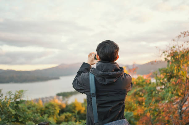 istock Asian men travel japan in autumn using digital devices connection technology uploading images to her friend at tourist spot at the top of amanohashidate viewpoint Japan 2070850047