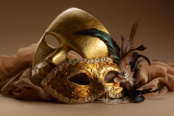 Golden Venetian carnival masks on a beige background.