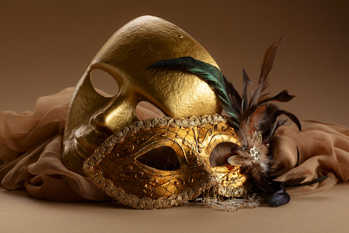 Golden Venetian carnival masks. Vintage masks on a beige background.