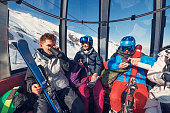 Family enjoying gondola ski lift ride in Alps