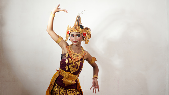 balinese girl dance gesture wearing Balinese traditional dress with a dancing gesture with crown, jewelry, and gold ornament accessories on white background