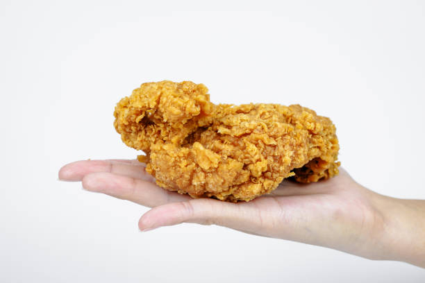 istock Female hand holding fried chicken on white background. 2070895279