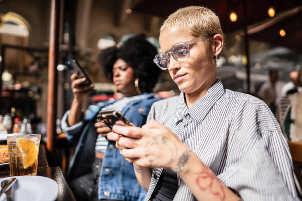 istock Young woman using mobile phone at restaurant 2070913086