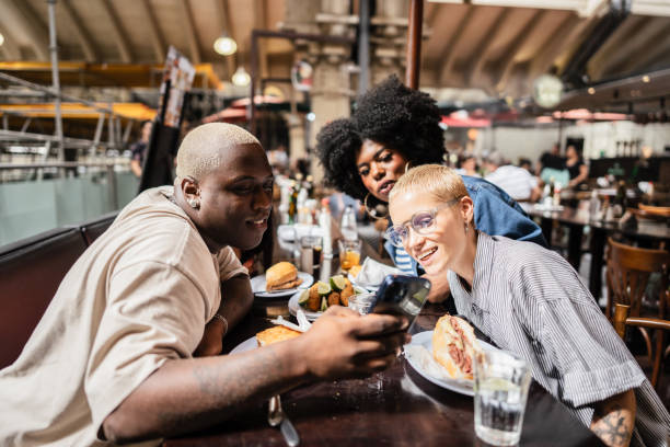 istock Group of friends using mobile phone at restaurant 2070915666
