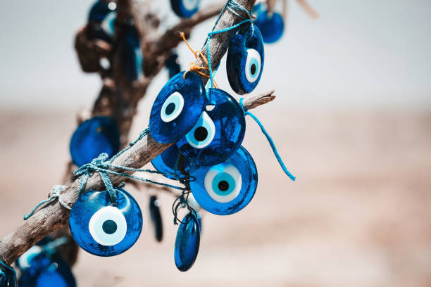 istock Traditional Turkish amulet Evil Eye or blue eye (Nazar boncugu) on tree brunch. Traditional Turkish amulet and souvenir. Close up, defocused background, copy space. Cappadocia, Turkiye (Turkey) 2070926038