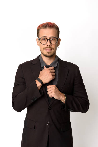 Young man fixing his tie and looking at camera.