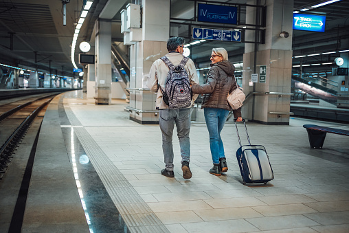 Mature couple of passengers with luggage at subway station