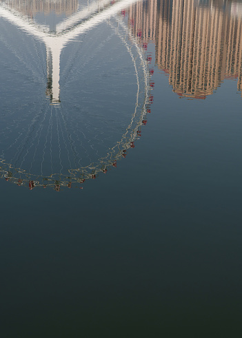 The reflection of the Ferris wheel in the water