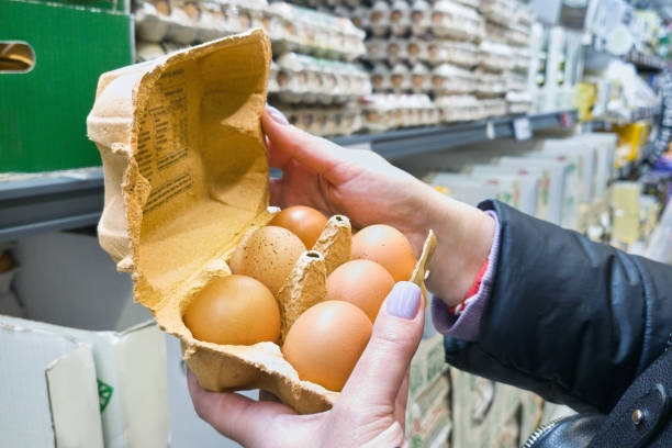 istock Hands with packages of eggs in store 2070930729