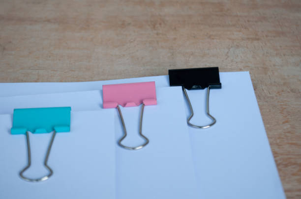 istock Side view of blank document papers with paper clips pastel on wooden table. 2070931081