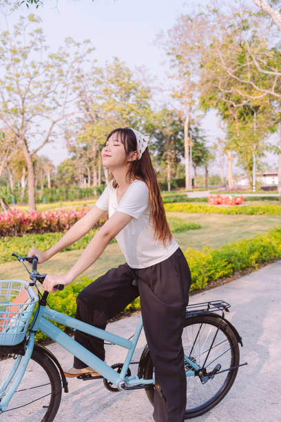 person with bike in nature park in vacation and mental wellbeing. - mental health women asian ethnicity bicycle photos et images de collection