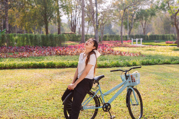 person with bike in nature park in vacation and mental wellbeing. - mental health women asian ethnicity bicycle zdjęcia i obrazy z banku zdjęć