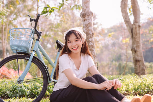 person with bike in nature park in vacation and mental wellbeing. - mental health women asian ethnicity bicycle photos et images de collection