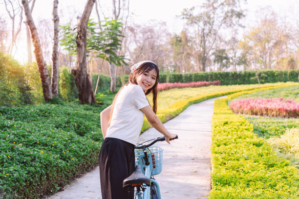 person with bike in nature park in vacation and mental wellbeing. - mental health women asian ethnicity bicycle photos et images de collection