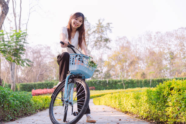 person with bike in nature park in vacation and mental wellbeing. - mental health women asian ethnicity bicycle photos et images de collection