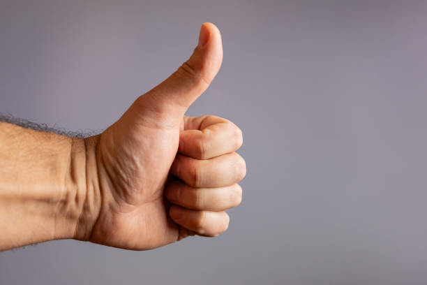 istock Human hand showing thumb up (like) gesture on gray background. 2070933624