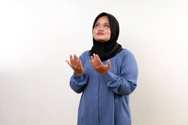 istock Asian muslim woman standing with praying gesture while looking above 2070933962