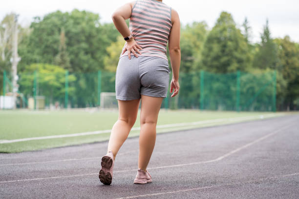 Pain in the hip during training, muscles cramped, massage on a sports ground after workout Pain in the hip during training, muscles cramped, massage on a sports ground after workout, health problems concept obese joint pain stock pictures, royalty-free photos & images