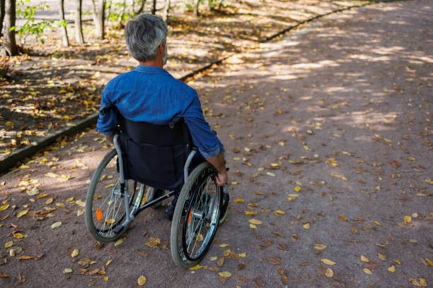 Close-Up of Elderly Hand on Wheelchair Wheel: Symbol of Mobility and Independence