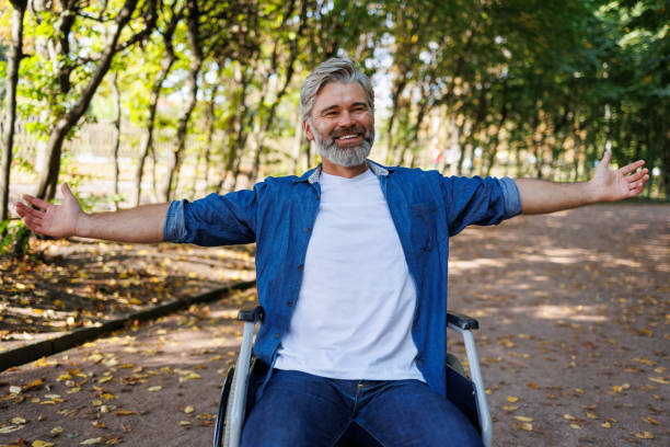 istock Embracing Nature: Man in Wheelchair Reaching Out in Park 2070984914