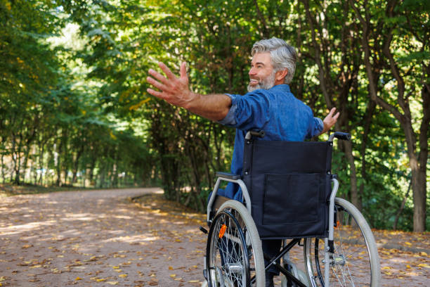 istock Embracing Independence: Wheelchair User Reaching in Park 2070986017