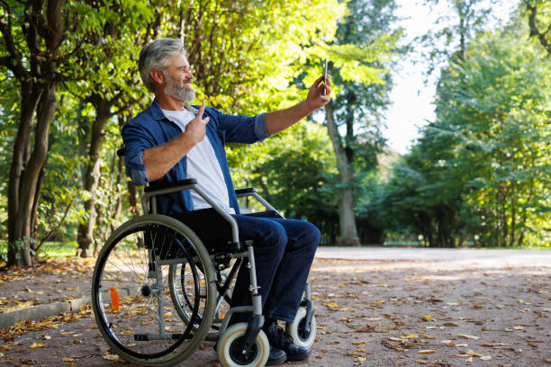 istock Inclusive Recreation: Man in Wheelchair Snaps Park Selfie 2070986588