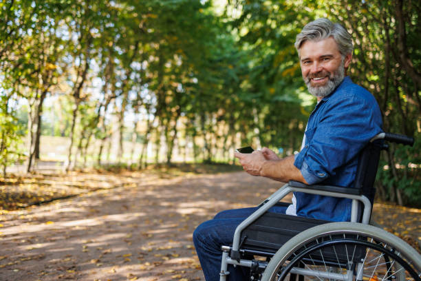 istock Adaptive Living: Wheelchair User Enjoying Park Scenery with Phone 2070987169