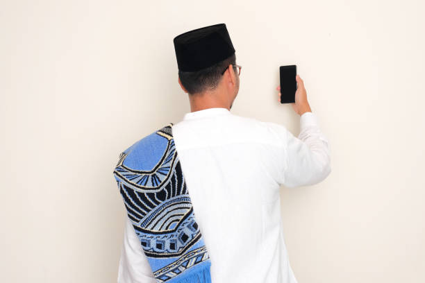 istock Back view of moslem man looking to mobile phone that he hold 2071004850