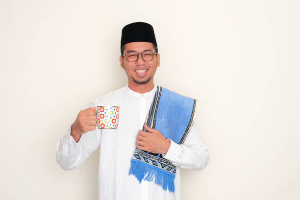 istock Moslem Asian man smiling happy while holding a drinking glass 2071009983