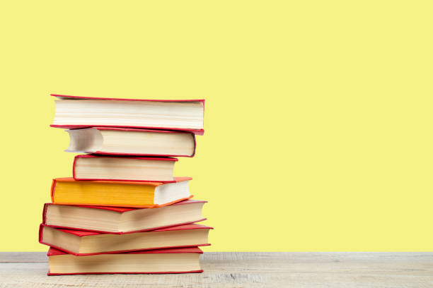 istock Composition with hardback books on wooden deck table and yellow background. Books stacking. Back to school. Copy Space. Education background. 2071050673