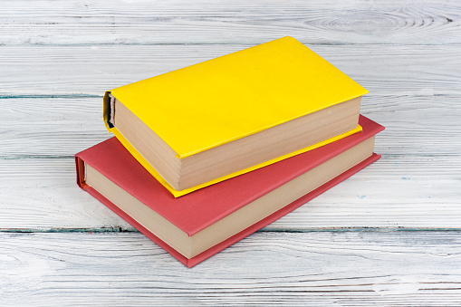 Multi-colored books on a white wooden table