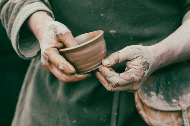 istock hands of a potter, creating an earthen jar on a pottery wheel 2071056551