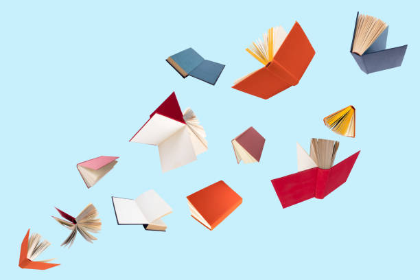 istock Colorful hardcover books flying isolated on blue background. 2071070056