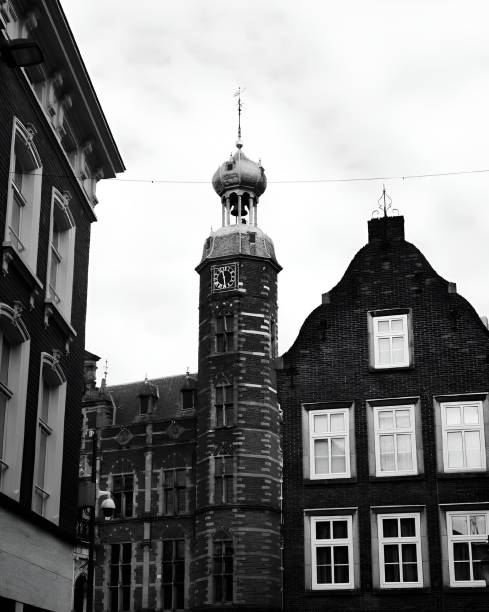 istock a tall tower standing out front of an older building with a clock 2071148379