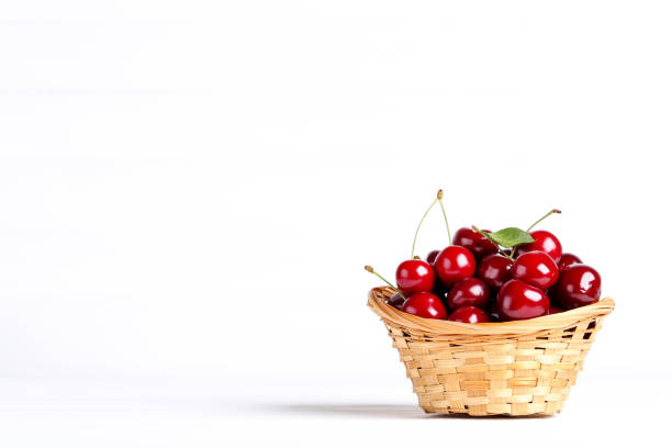 Sweet cherries in basket on white background
