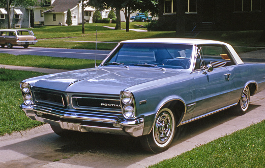 Shiny new 1965 Pontiac Tempest parked in suburban driveway. Waterloo, Iowa, USA. Scanned film.