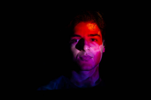 istock colorful lights on a young man's face 2071177041