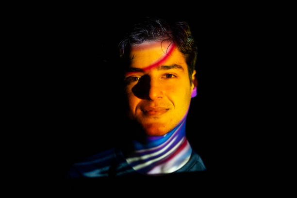 istock colorful lights on a young man's face 2071177042