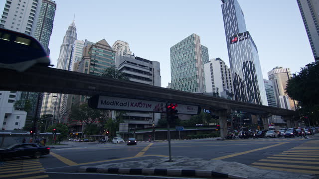 Monorail train crossing above busy streets against the Kuala Lumpur skyline