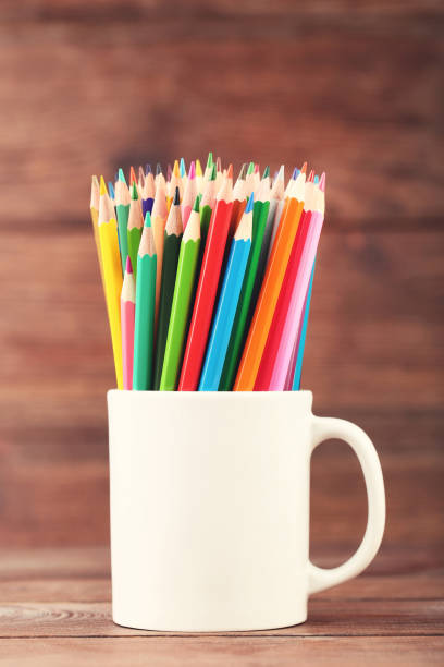 istock Colored pencils in white cup on wooden table 2071213825