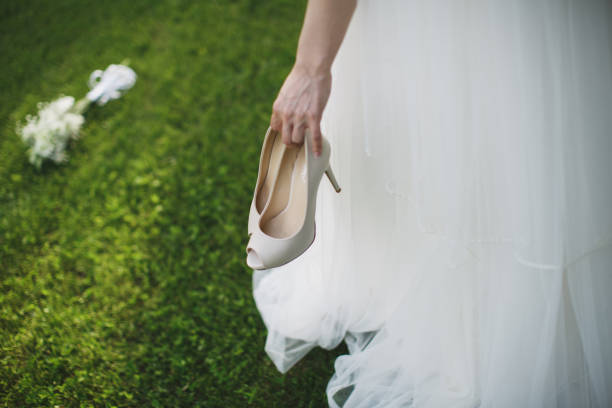 istock bride holding a shoe in her hand 2071215695