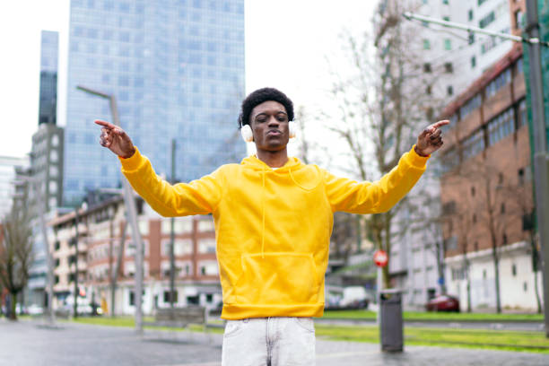 African young adult feeling the beat dancing outdoors in the city.