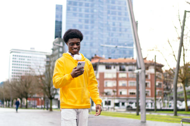 istock Cheerful African Young Man Using Smartphone in Urban Park 2071244212