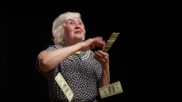 Funny grandmother making money rain against black background, lottery winner