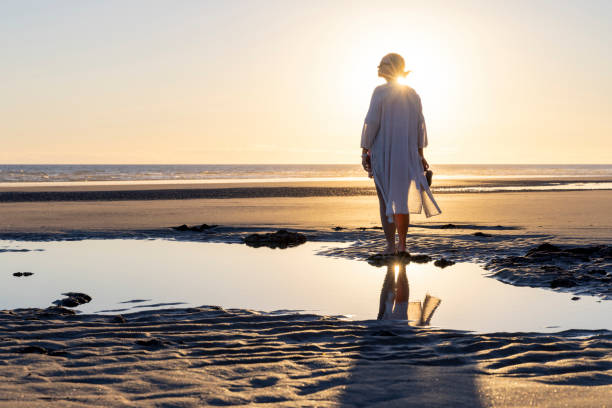 Mature woman walks along empty beach