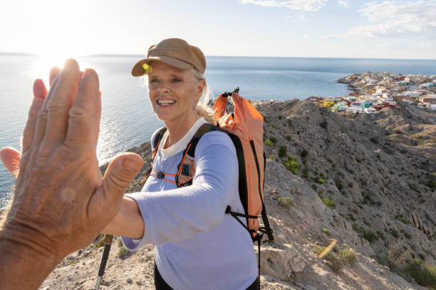 Mature couple high-five on mountain ridge