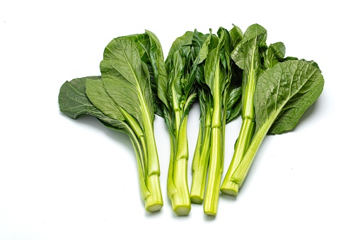 Leaves of different types of kale cabbage top view. Green cabbage leaves on white background. Leaves of different sizes and colors close-up. Greens for making salad, detox. varieties of cabbage