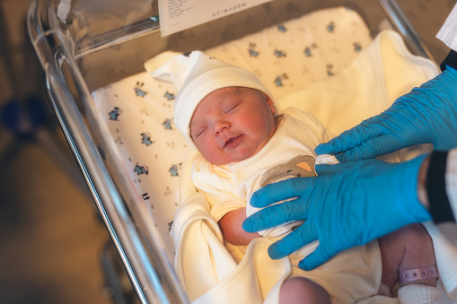 a newborn baby in a hospital smiling