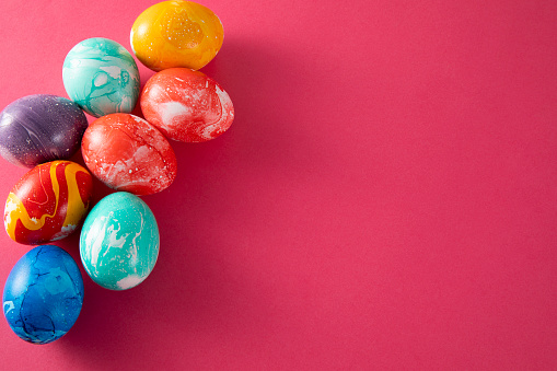 Hand colored colorful easter eggs on pink background